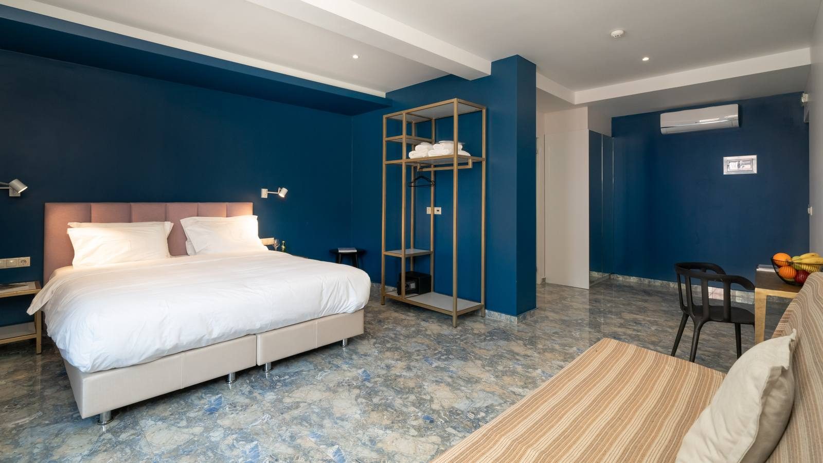 Apartment with a deep blue wall and a king-size bed